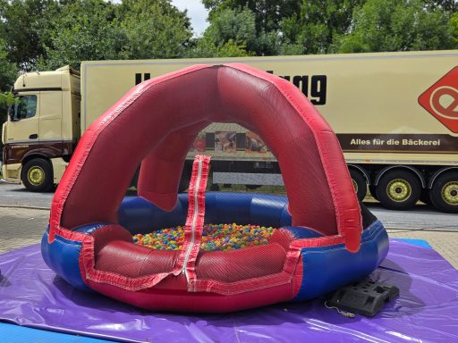 Bunte Hüpfburg mit einer Kuhle voller bunter Kunststoffkugeln.