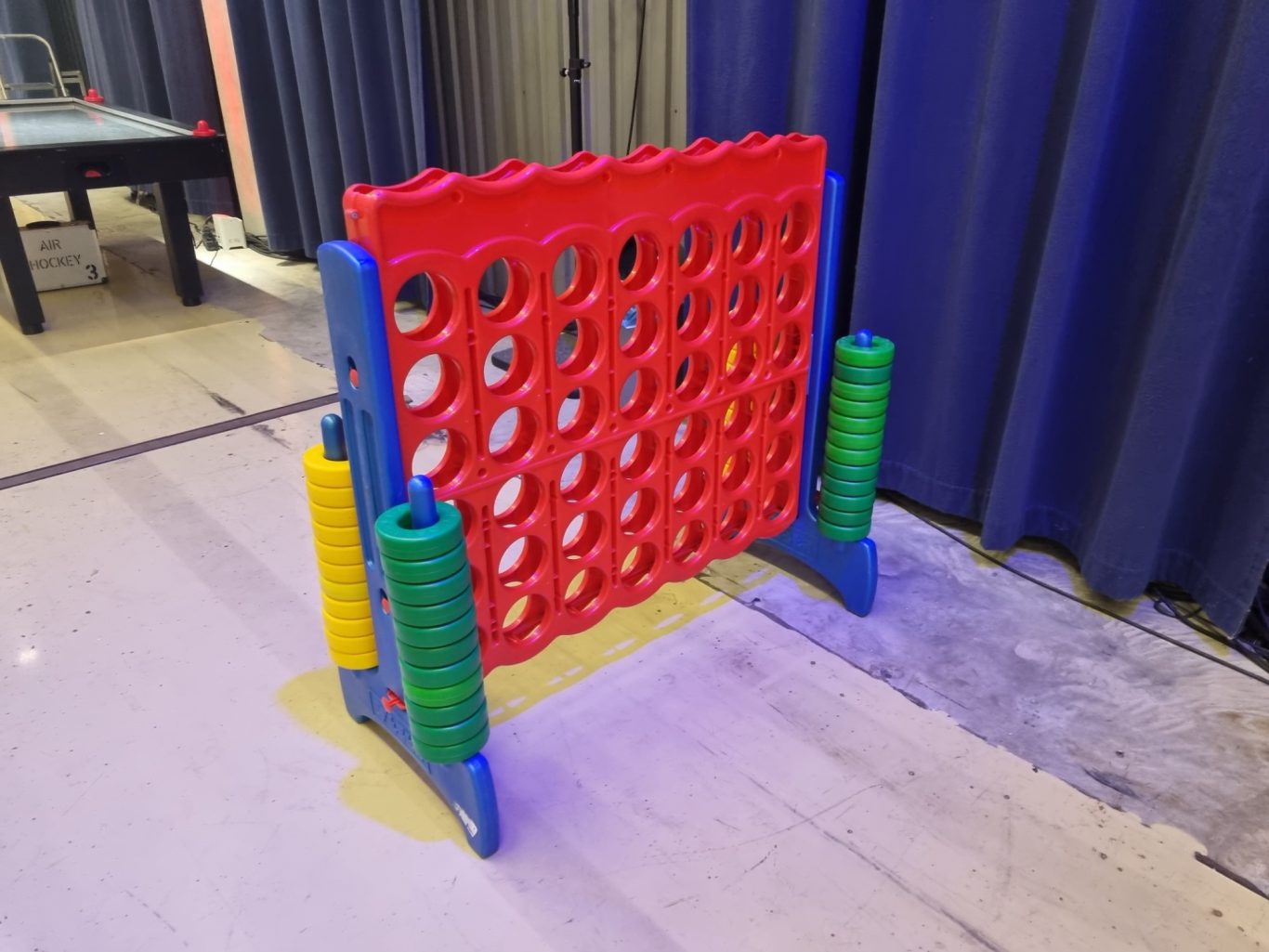 Vier-Gewinnt-XXL Buntes Connect Four Spiel mit roten und blauen Chips und seitlichen Aufbewahrungsrollen.