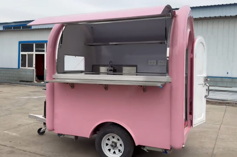 Pink Foodtruck mit offenem Fenster und Verkleidung, bereit zum Verkauf von Speisen.